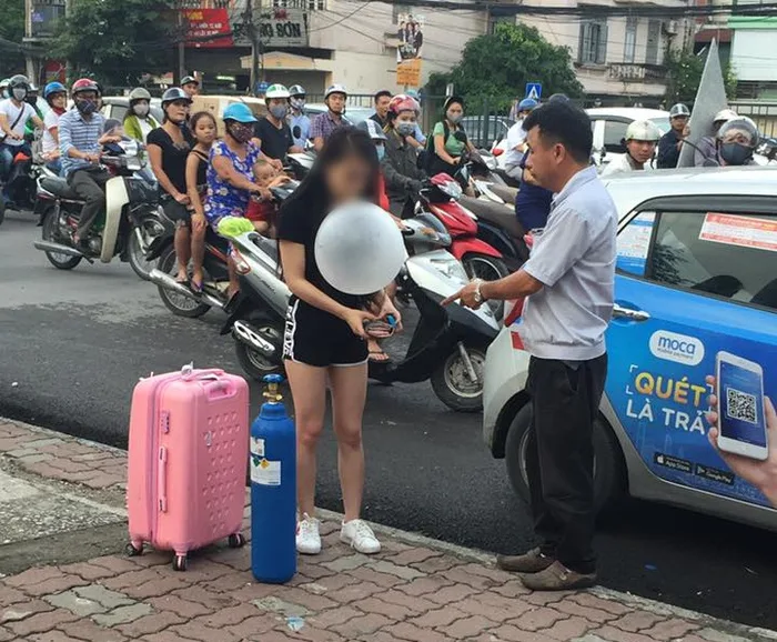 Cô gái xinh đẹp kéo theo cả bình khí cười ra giữa đường Hà Nội để hít xong  quỵt tiền taxi